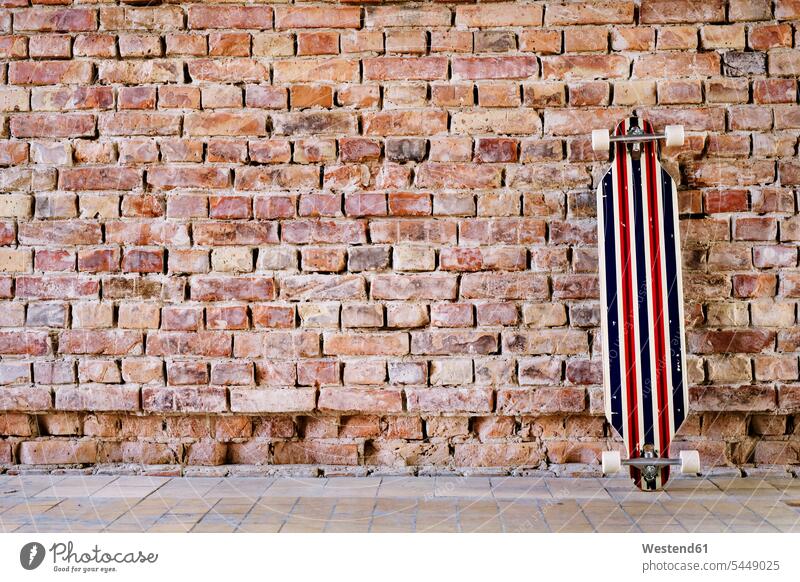 Longboard an Ziegelmauer im Büro Skateboard Rollbretter Skateboards Ziegelwand Backsteinmauer Office Büros Backsteinwand Backsteinmauern Mauer Mauern Wand Wände