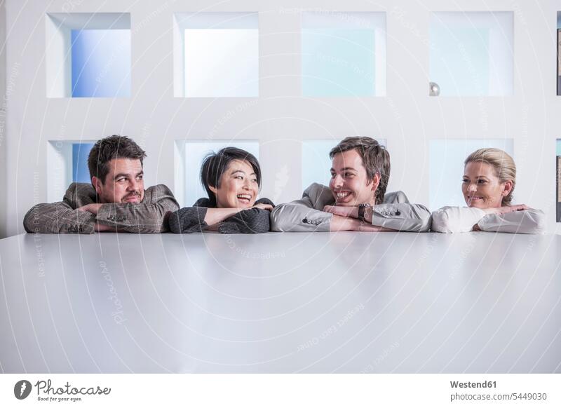 Vier lächelnde Kollegen im Amt Team Büro Office Büros Arbeitskollegen Arbeitsplatz Arbeitsstätte Arbeitstelle Business Geschäftsleben Geschäftswelt geschäftlich