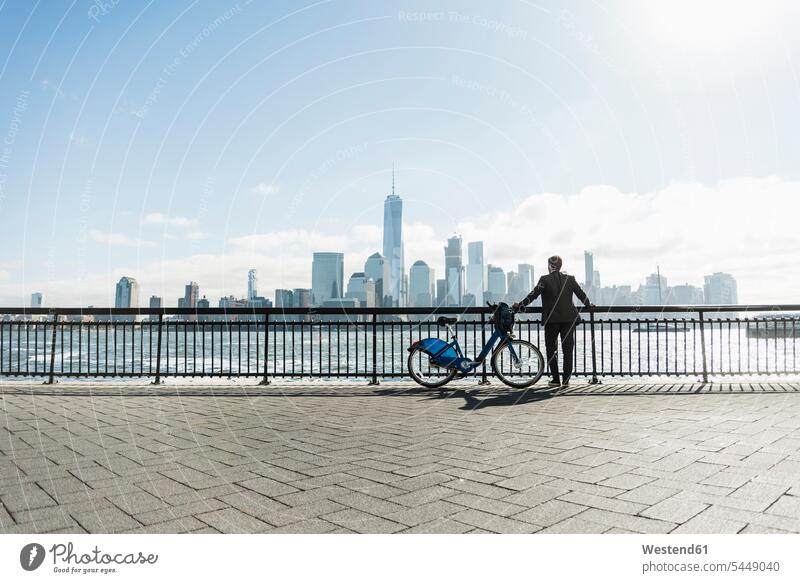 USA, Mann mit Fahrrad am Hafen von New Jersey mit Blick auf Manhattan Bikes Fahrräder Räder Rad New York New York State Männer männlich Geschäftsmann
