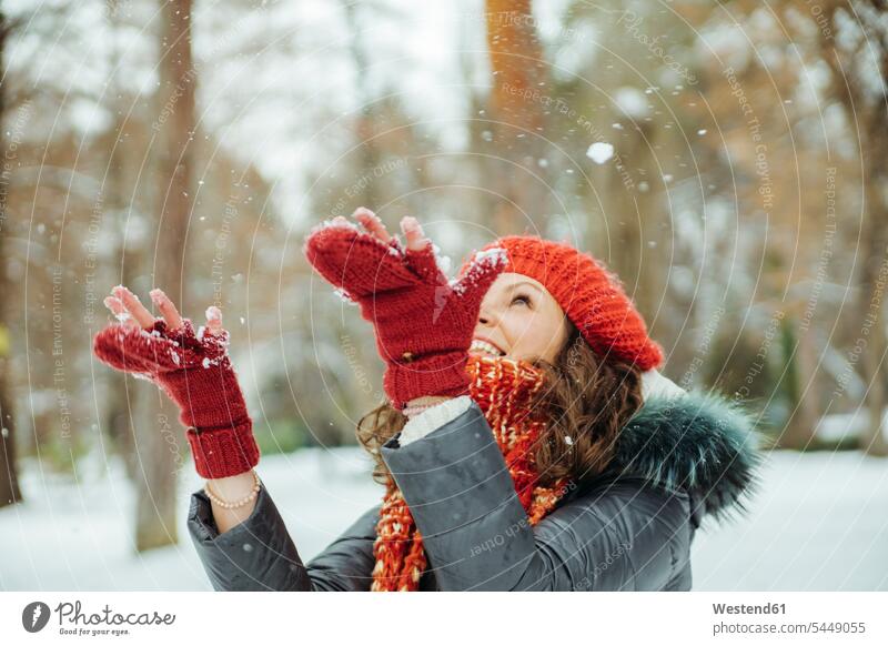 Glückliche Frau fängt Schneeflocken weiblich Frauen Wetter Erwachsener erwachsen Mensch Menschen Leute People Personen Winter winterlich Winterzeit glücklich