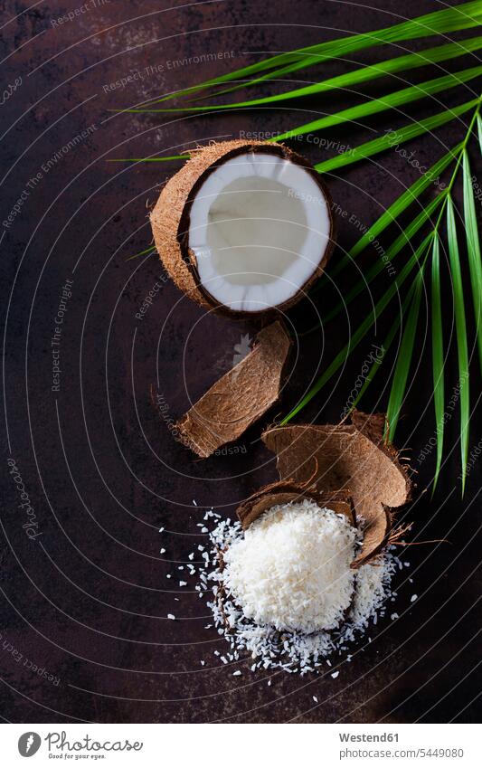 Geöffnete Kokosnuss, Kokosnussschale und Kokosflockenstapel braun tropisch Zutaten Weihnachtsbäckerei Weihnachtsbaeckerei hohl ausgehöhlt geöffnet offen