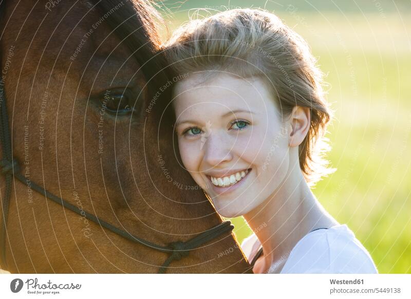 Porträt einer glücklichen jungen Frau mit Pferd Portrait Porträts Portraits Kopf an Kopf natürlich Natuerlichkeit natuerlich Natürlichkeit lächeln Blickkontakt