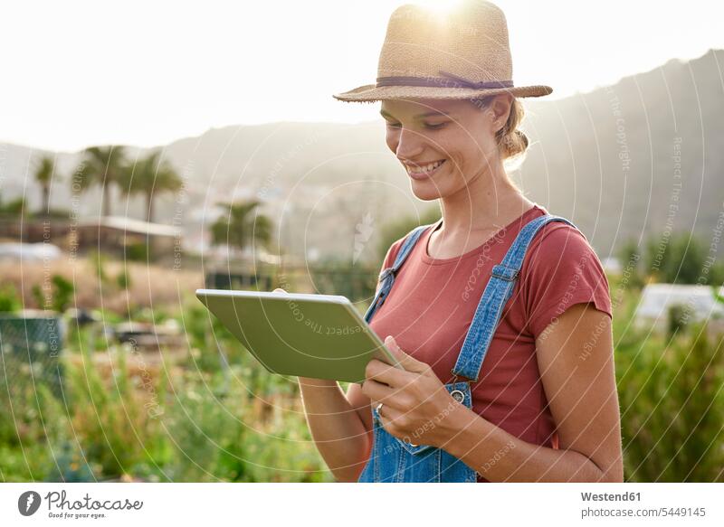 Spanien, Kanarische Inseln, Gran Canaria, lächelnde junge Frau betrachtet Tablette Tablet Computer Tablet-PC Tablet PC iPad Tablet-Computer Portrait Porträts