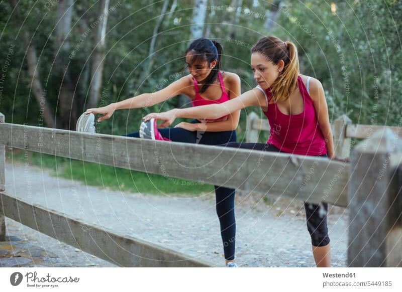 Zwei aktive Frauen strecken sich an einer Ziegelmauer Trainieren Übung Üben Übungen weiblich Freundinnen dehnen Erwachsener erwachsen Mensch Menschen Leute