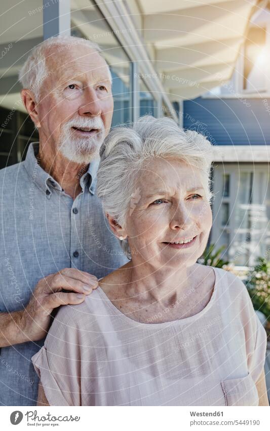 Senoir-Paar steht in seinem Haus und sieht zuversichtlich aus glücklich Glück glücklich sein glücklichsein Pärchen Paare Partnerschaft Älter werden