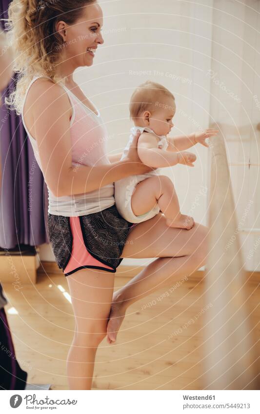 Zwei Mütter, die ihre kleinen Kinder im Tanzstudio zum Barren halten trainieren Spaß Spass Späße spassig Spässe spaßig lächeln Mutter Mami Mutti Mama Baby