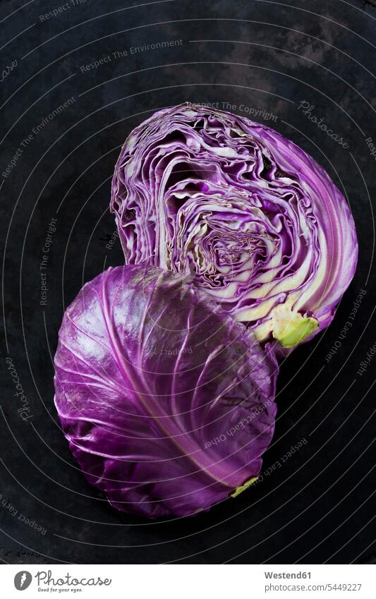 Zwei Hälften violetter Sweetheart Cabbage auf dunklem Grund Spitzkohl Spitzkraut Frische frisch Gesunde Ernährung Ernaehrung Gesunde Ernaehrung Gesundheit