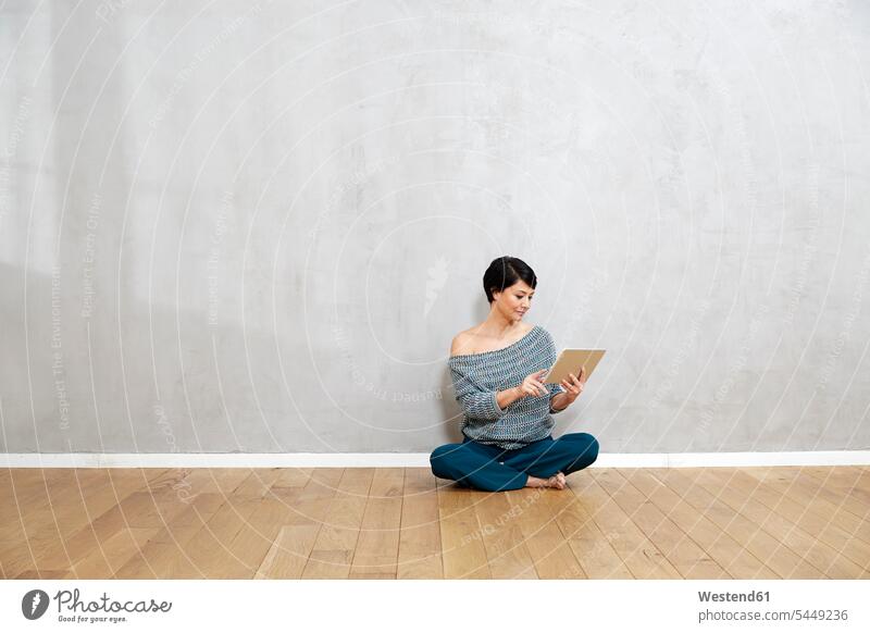 Frau sitzt mit Tablette auf dem Boden Tablet Computer Tablet-PC Tablet PC iPad Tablet-Computer weiblich Frauen sitzen sitzend Rechner Erwachsener erwachsen