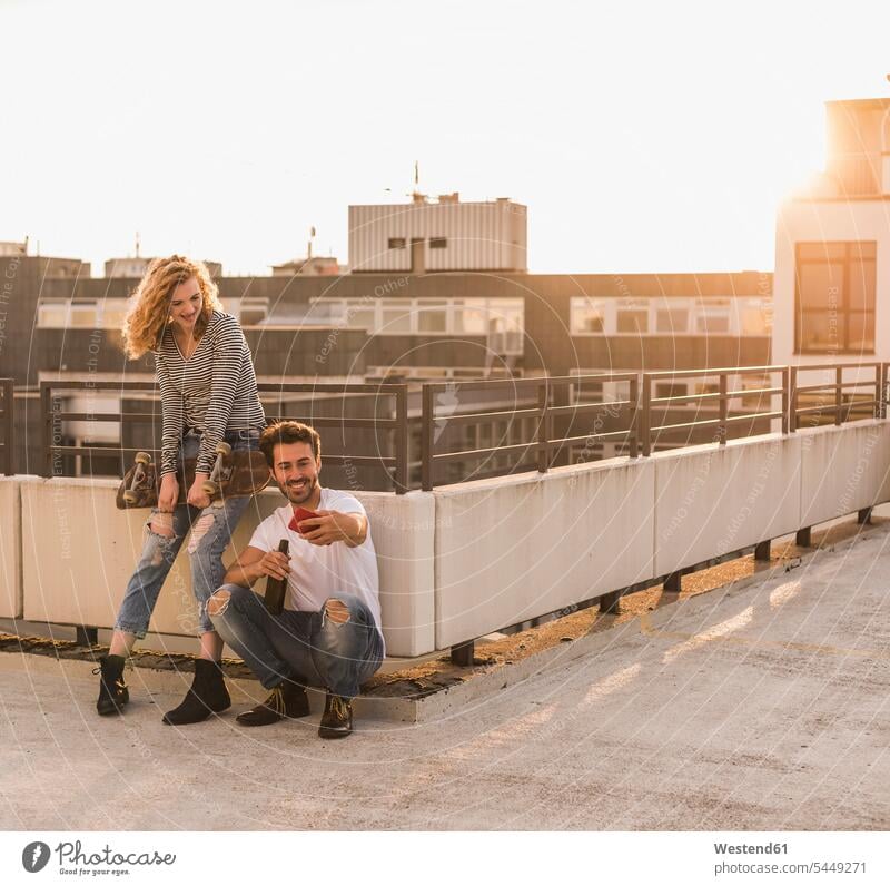 Junges Paar entspannt auf Dachterrasse bei Sonnenuntergang und macht Selfie mit Handy Entspannung Entspannen relaxen entspannen Smartphone iPhone Smartphones