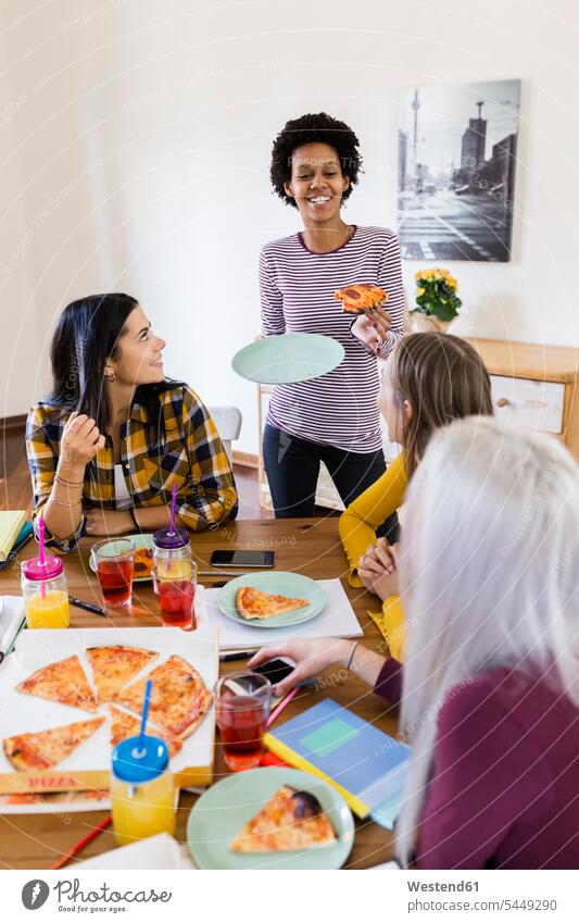 Gruppe junger Frauen, die zu Hause studieren und Pizza essen Studentin Zuhause Bildung Essen Food and Drink Erwachsener Mensch Internet Gruppenarbeit Lehrbuch
