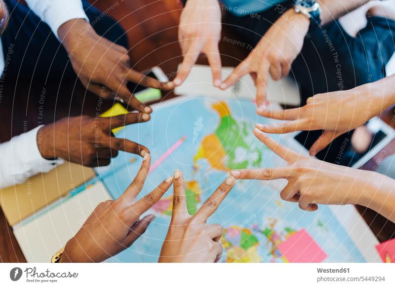 Gruppe von Freunden macht Handzeichen über der Weltkarte reisen verreisen Karte Karten Hände Freundschaft Kameradschaft Mensch Menschen Leute People Personen