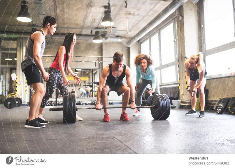 Gruppe junger fitter Menschen jubelt beim Gewichtheben im Fitnessstudio trainieren Kraftsport Sport Fitnessclubs Fitnessstudios Turnhalle Gesundheit gesund
