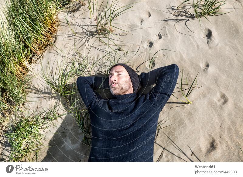 Mann mit Wollmütze in Stranddüne liegend Sanddüne Sanddünen Beach Straende Strände Beaches schlafen schlafend entspannt entspanntheit relaxt liegt Männer