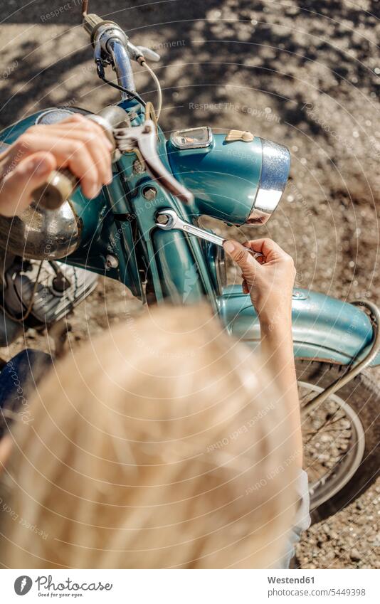 Frau repariert Oldtimer-Motorrad Motorräder weiblich Frauen reparieren Reparatur Kraftfahrzeug Verkehrsmittel KFZ Erwachsener erwachsen Mensch Menschen Leute
