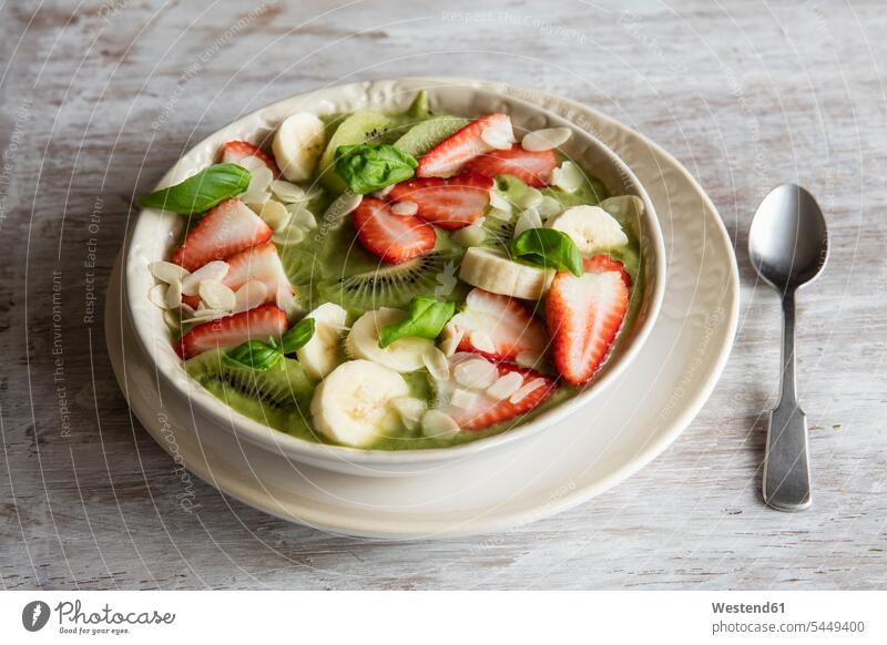 Smoothie-Schüssel mit Erdbeeren, Banane, Kiwi und Mandelsplittern Frühstück frühstücken servierfertig angerichtet Frische frisch Gesunde Ernährung Ernaehrung