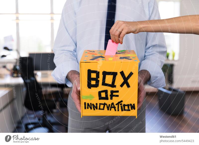 Geschäftsmann sammelt innovative Vorschläge in gelber Box Innovation Neuheit Neuerung Innovationskraft gelbes sammeln gesammelt einwerfen Businessmann