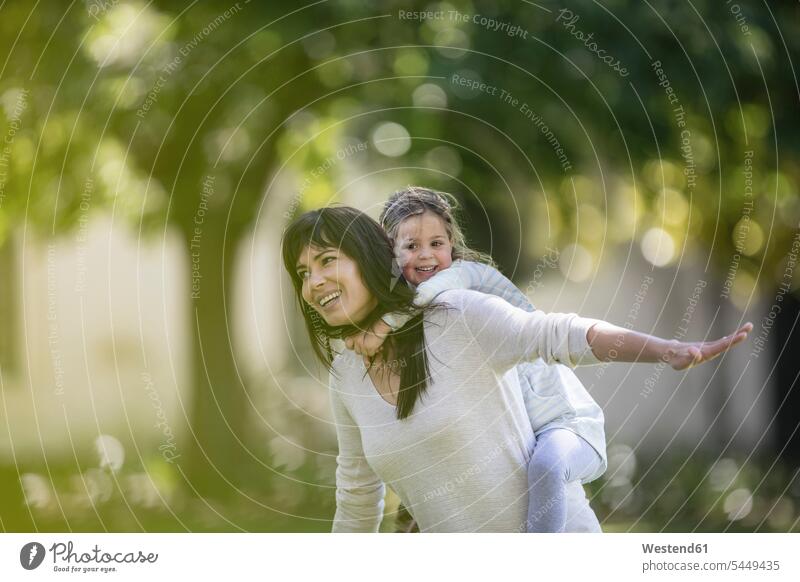 Mutter schaukelt ihre Tochter im Garten spielen Töchter Mami Mutti Mütter Mama glücklich Glück glücklich sein glücklichsein Kind Kinder Familie Familien Mensch