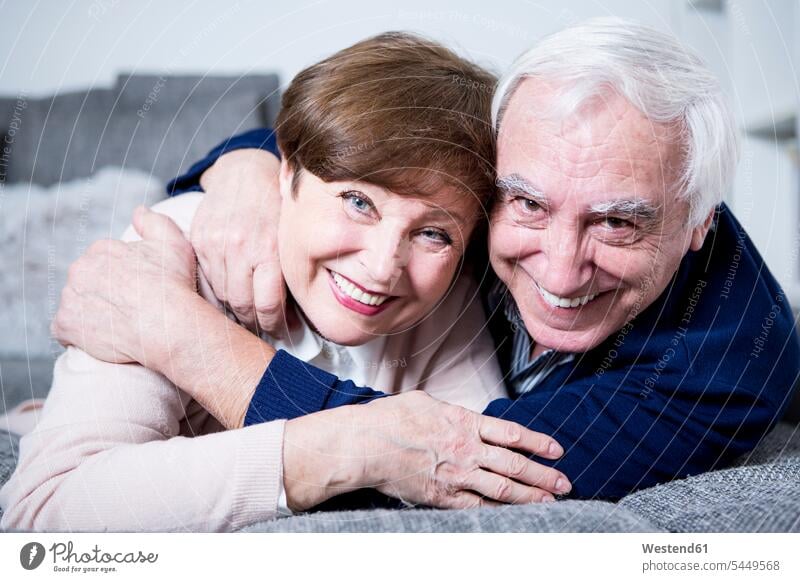 Älteres Ehepaar liegt auf dem Sofa und umarmt sich Couches Liege Sofas umarmen Umarmung Umarmungen Arm umlegen Paar Pärchen Paare Partnerschaft Senioren alte