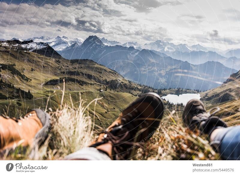 Deutschland, Bayern, Oberstdorf, Füsse von zwei Wanderern, die sich in alpiner Landschaft ausruhen Gebirge Berglandschaft Gebirgslandschaft Gebirgskette