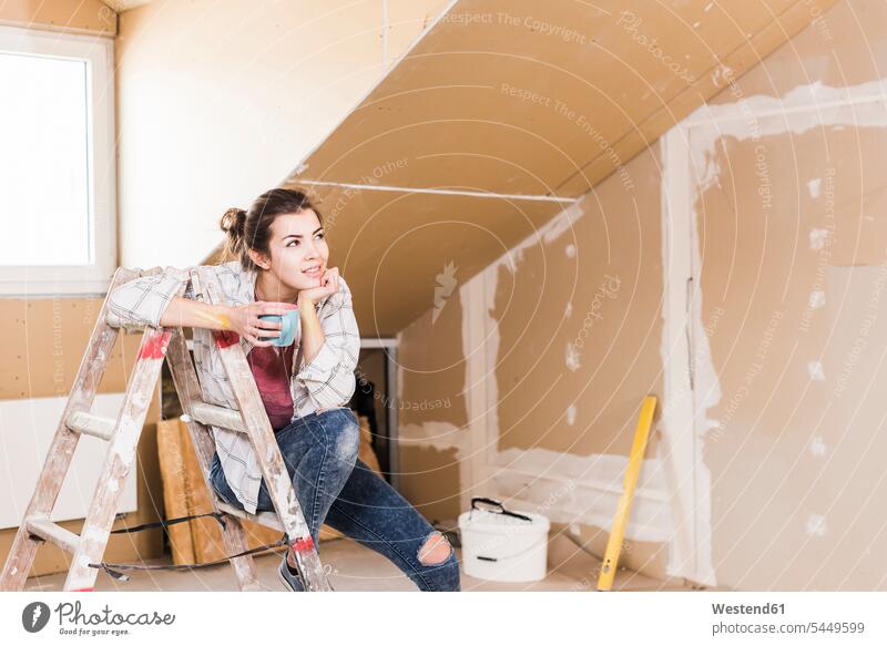Junge Frau, die über die Renovierung ihres neuen Hauses nachdenkt Heimwerken Do-it-Yourself DIY junge Frau junge Frauen Leiter Leitern Eigenheim Eigenheime