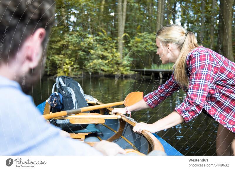 Junge Frau zieht Kanu auf einem Waldbach mit Mann ziehen Bach Bäche Baeche Paar Pärchen Paare Partnerschaft weiblich Frauen Forst Wälder Kanus Gewässer Wasser