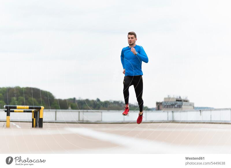 Junger Mann rennt auf Parkebene trainieren laufen rennen Joggen Jogging Männer männlich Fitness fit Gesundheit gesund Sport Erwachsener erwachsen Mensch