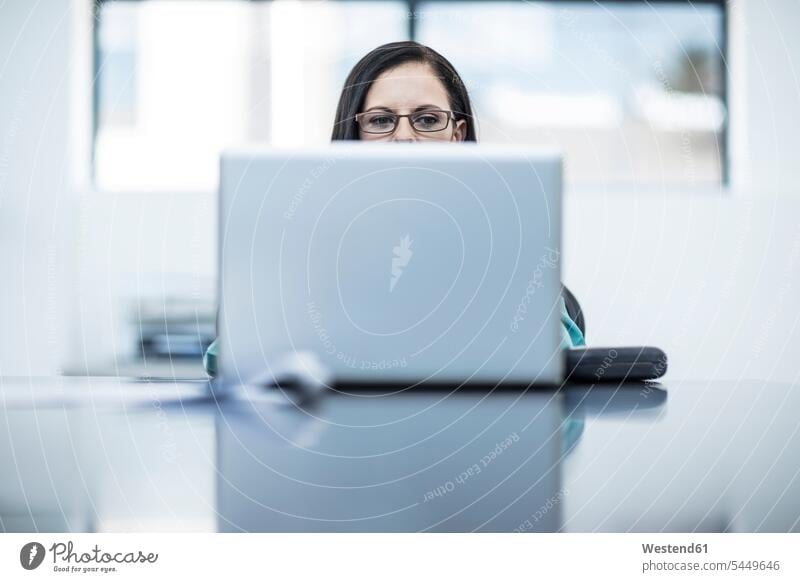 Frau mit Brille mit Laptop im Büro Beruf Berufstätigkeit Berufe Beschäftigung Jobs Office Büros Laptop benutzen Laptop benützen Business Geschäftsleben
