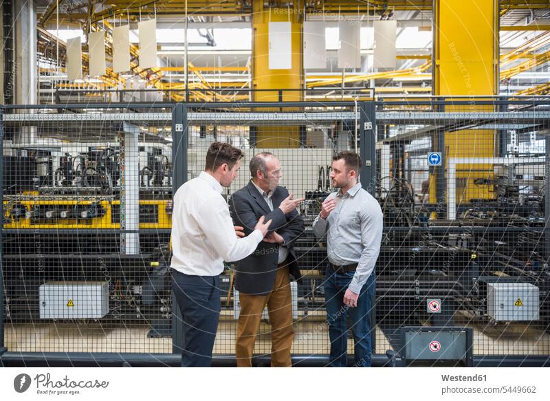 Drei Männer im Gespräch in der Fabrikhalle Fabriken Mann männlich sprechen reden Kollegen Arbeitskollegen arbeiten Erwachsener erwachsen Mensch Menschen Leute