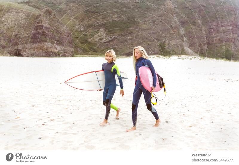 Spanien, Aviles, zwei junge Surfer, die am Strand spazieren Wellenreiter Beach Straende Strände Beaches Surfbrett Surfbretter surfboard surfboards Teenager