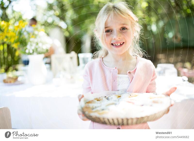 Porträt eines lächelnden Mädchens, das eine Torte im Freien hält Kuchen weiblich Süßspeise Süsses Süßes süß Süßspeisen Essen Food Food and Drink Lebensmittel
