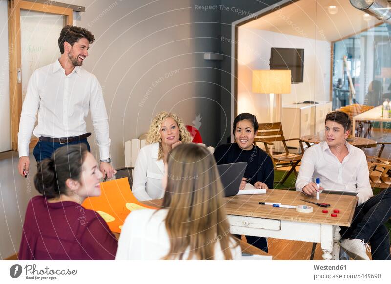 Geschäftsleute, die an einem Workshop im Büro teilnehmen Führerschaft Projektarbeit lernen Tafel erklären Planung Strategie Kollegin Meeting Einfallsreichtum