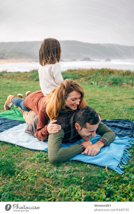 Glückliche Familie auf Decke an der Küste Decken Kueste Kuesten Küsten glücklich glücklich sein glücklichsein Familien Mensch Menschen Leute People Personen