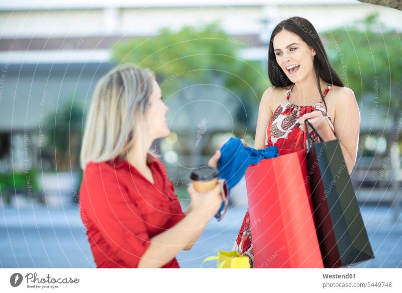 Zwei glückliche Frauen mit Einkaufstaschen Freundinnen lachen Shopping einkaufen shoppen Glück glücklich sein glücklichsein Freunde Freundschaft Kameradschaft