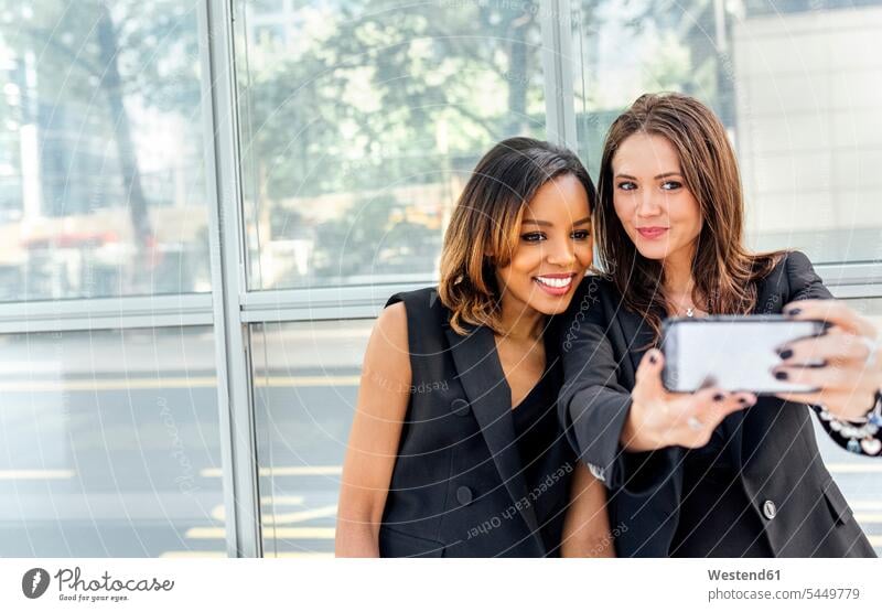 Zwei Frauen machen ein Selfie in der Stadt Selfies Handy Mobiltelefon Handies Handys Mobiltelefone weiblich Freundinnen Telefon telefonieren Kommunikation