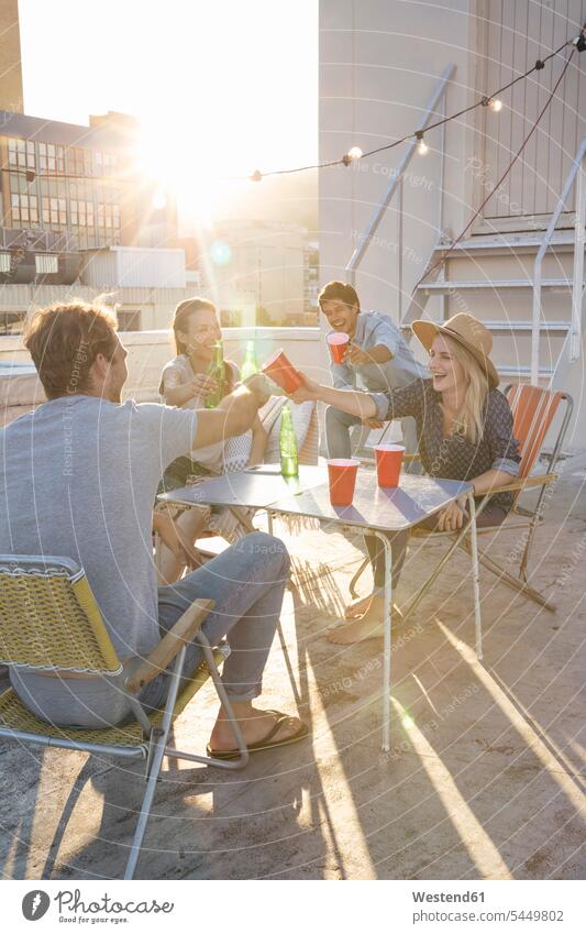Freunde feiern an einem schönen Sommerabend eine Party auf dem Dach Gemeinsam Zusammen Miteinander Dachterrasse Dachterrassen genießen geniessen Genuss