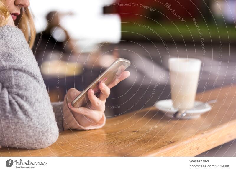 Frauenhand hält Smartphone weiblich Hand Hände halten Cafe Kaffeehaus Bistro Cafes Kaffeehäuser iPhone Smartphones Erwachsener erwachsen Mensch Menschen Leute