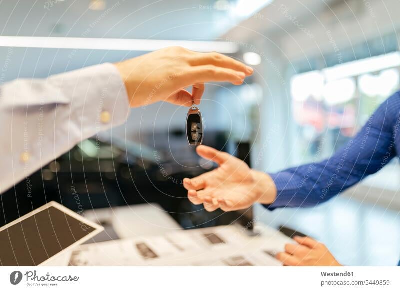 Verkäufer übergibt Autoschlüssel an Kunden verkaufen Kundschaft Kauf Wagen PKWs Automobil Schlüssel Mensch Menschen Leute People Personen Kraftfahrzeug