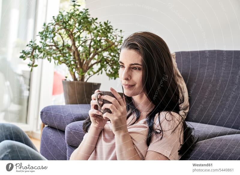 Junge Frau mit Kaffeebecher zu Hause entspannt entspanntheit relaxt weiblich Frauen Getränk Getraenk Getränke Getraenke Food and Drink Lebensmittel