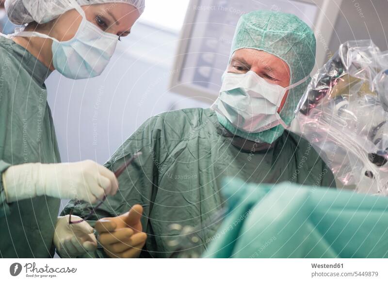 OP-Schwester, die das Instrument während einer Operation übergibt Operationen operieren Chirurgie Operationsschwester Instrumentenschwestern OP-Schwestern