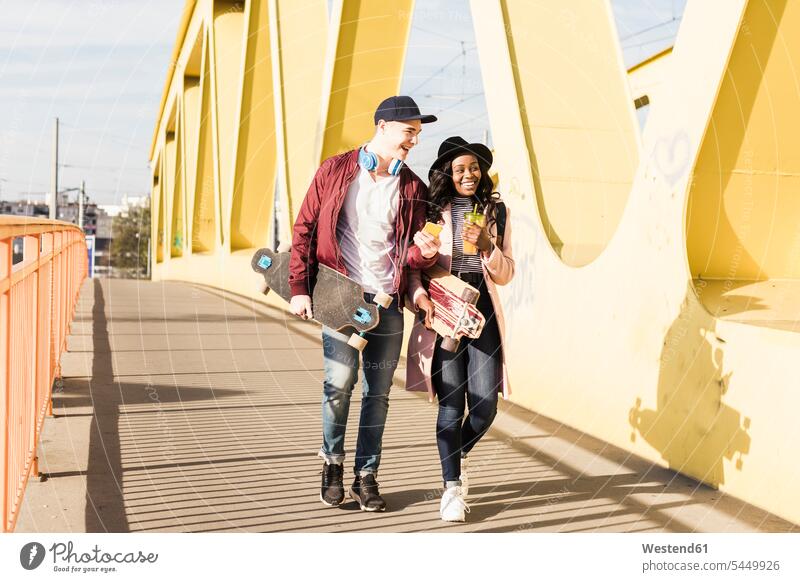 Junges Paar mit Skateboard auf der Brücke Rollbretter Skateboards Spaß Spass Späße spassig Spässe spaßig Bruecken Brücken glücklich Glück glücklich sein