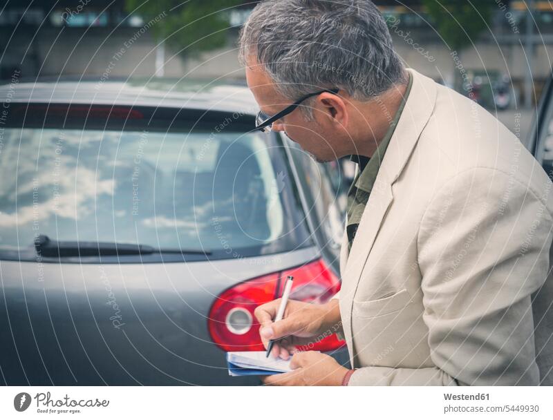 Geschäftsmann notiert Lizenznummer Mann Männer männlich Auto Wagen PKWs Automobil Autos Erwachsener erwachsen Mensch Menschen Leute People Personen