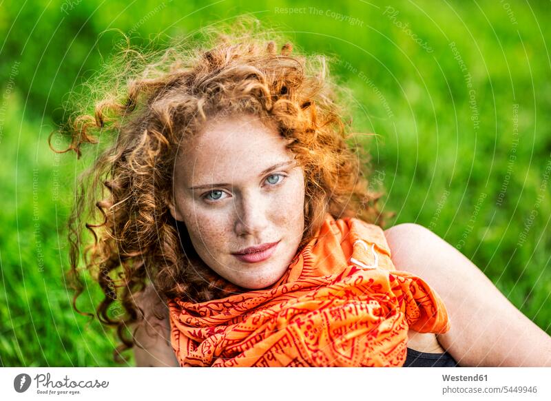 Porträt einer sommersprossigen jungen Frau mit lockigem roten Haar und orangem Schal Portrait Porträts Portraits weiblich Frauen Erwachsener erwachsen Mensch