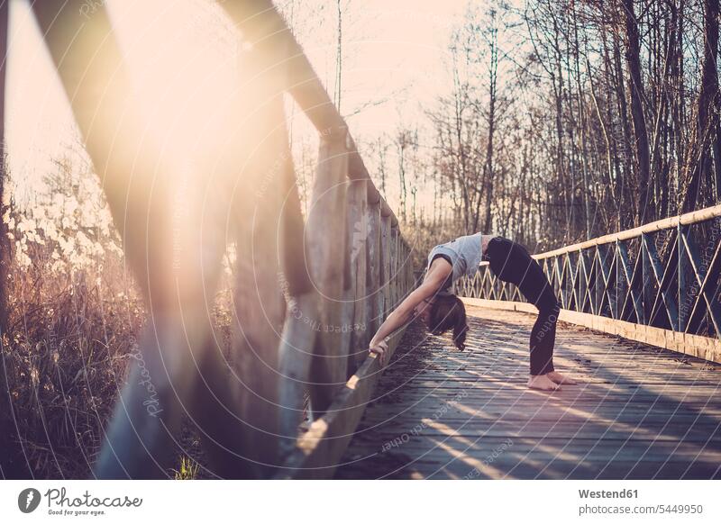 Frau macht Rad-Pose auf einer Brücke Yoga Yoga-Übungen Yogauebungen Yogaübungen Jogauebung Jogauebungen weiblich Frauen Bruecken Brücken Natur Achtsamkeit