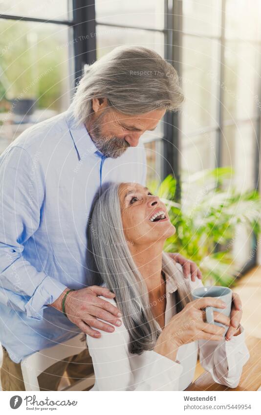 Glückliches älteres Ehepaar trinkt zu Hause Kaffee sitzen sitzend sitzt Paar Pärchen Paare Partnerschaft glücklich glücklich sein glücklichsein Senioren alte