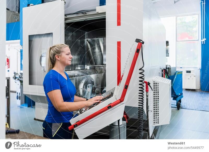 Frau bedient Bedienfeld in einer Industriefabrik Fabrik Fabriken arbeiten Arbeit weiblich Frauen Maschine Maschinen Erwachsener erwachsen Mensch Menschen Leute