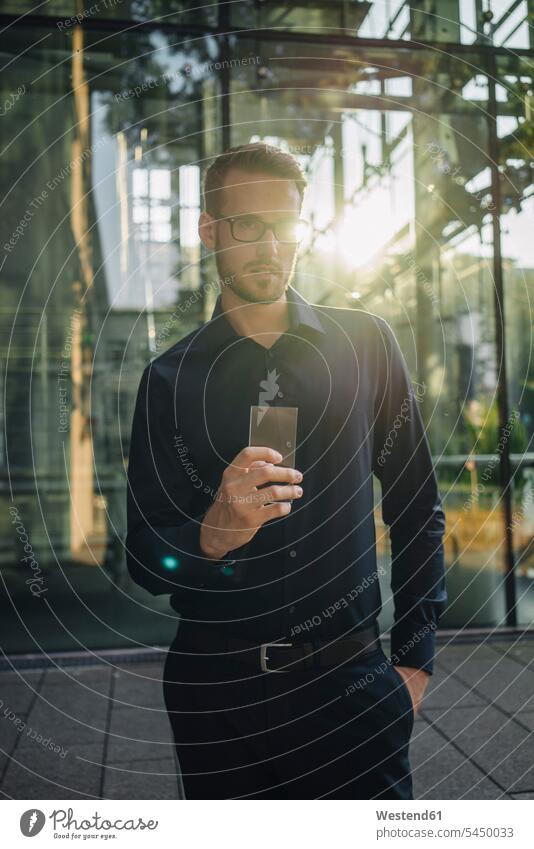Geschäftsmann hält futuristisches tragbares Gerät Mann Männer männlich Handy Mobiltelefon Handies Handys Mobiltelefone Innovation innovativ Neuheit Neuerung