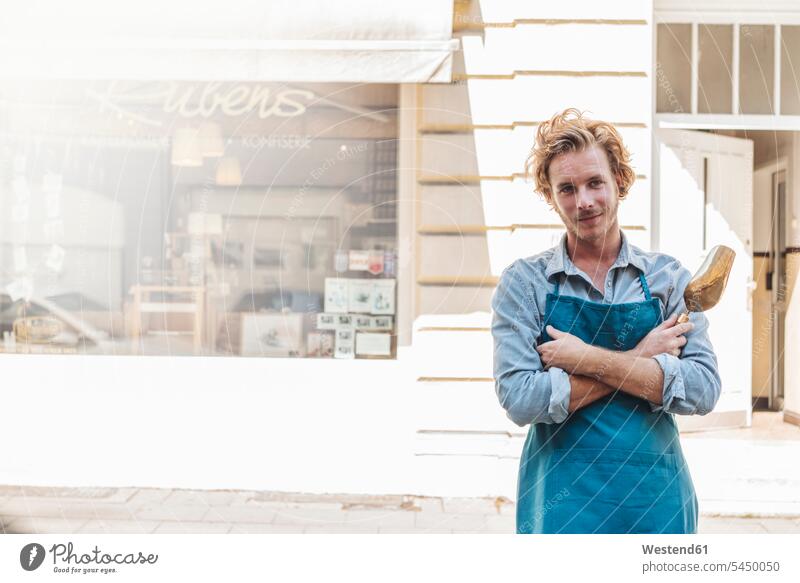 Porträt eines selbstbewussten Kaffeerösters vor seinem Geschäft Mann Männer männlich lächeln Shop Laden Läden Geschäfte Shops Portrait Porträts Portraits