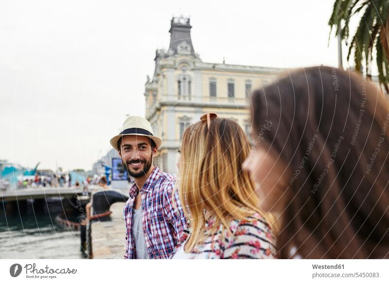 Spanien, Barcelona, drei Touristen an einem Pier in der Stadt lächeln Freunde Tourismus Freundschaft Kameradschaft am Wasser Freizeit Muße glücklich Glück