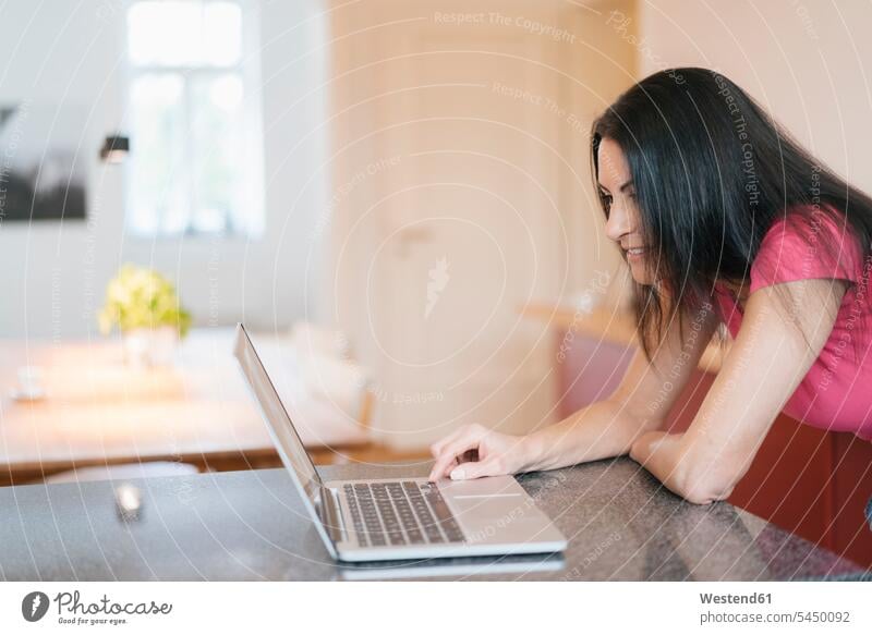 Frau benutzt Laptop zu Hause Notebook Laptops Notebooks weiblich Frauen Computer Rechner Erwachsener erwachsen Mensch Menschen Leute People Personen Zuhause