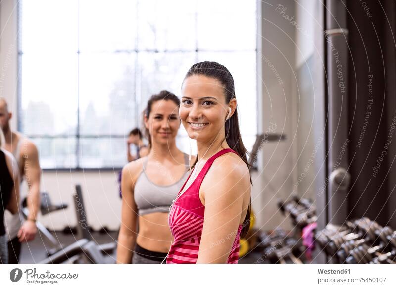 Junge Frauen im Fitnessstudio lächeln selbstbewusst fit Fitnessclubs Fitnessstudios Turnhalle junge Frau junge Frauen sportlich trainieren Gesundheit gesund